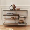 A modern, asymmetrical shelf unit made of metal and wood-look material, displayed in a well-lit room. Produktbild-Vorschau