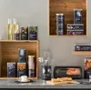 A kitchen counter with various food storage containers, bottles, and utensils, arranged on wooden shelves and the counter. Produktbild-Vorschau