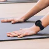 A person's hands are on a yoga mat, wearing a smartwatch. Náhľad obrázku produktu