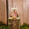 Eine kleine Eule aus Holz mit einem Schild in der Aufschrift Danke und einer roten Blume steht auf einem Baumstumpf vor einem hölzernen Hintergrund umgeben von Moos. Productafbeelding-voorbeeld
