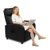 A woman sits in a black recliner chair using a laptop. Podgląd zdjęcia produktu