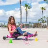 A young girl is playing on a pink trike on a beach with palm trees in the background. Anteprima dell’immagine prodotto