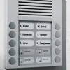 A close-up of a silver intercom system mounted on a textured wall, featuring multiple buttons and labels with names and 'Licht ein' (light on). Voir les images du produit