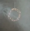 A decorative LED wreath with warm white lights hangs against a textured gray background. Produktbild-Vorschau