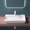 A white ceramic sink with a modern faucet is mounted on a wooden countertop against a teal wall, with a backlit mirror above. Produktbild-Vorschau