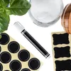 A flat lay of a chalk marker, round stickers, and a jar of white powder, with some basil leaves. Produktbild-Vorschau