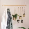 A wooden rod mounted on the wall with two jackets hanging on it and several small potted plants hanging from the rod. Anteprima dell’immagine prodotto