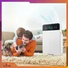 A father and son are lying on a rug with their dog, looking at a phone, while an air purifier operates in the background. Podgląd zdjęcia produktu