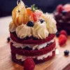 A close-up of a red velvet dessert with cream and berries. Produktbild-Vorschau