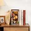 A miniature diorama of a Japanese alleyway, resembling a book nook, is placed between several books on a wooden shelf. Voir les images du produit