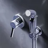 A chrome bidet faucet and hand sprayer are mounted on a textured gray wall. Produktbild-Vorschau