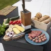 A collection of food items and kitchenware arranged on an outdoor table, likely for a barbecue. Voir les images du produit
