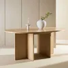 A light wood oval dining table with a minimalist design, featuring a vase with greenery and a candle on top. Voir les images du produit