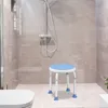 A shower stool with a blue seat is placed in a tiled shower stall next to a toilet. Produktbild-Vorschau