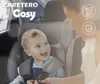 A baby is sitting in a car seat, looking at an adult. Produktbild-Vorschau
