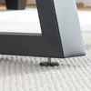 Close-up of a black metal table leg with an adjustable foot resting on a white textured rug. Podgląd zdjęcia produktu