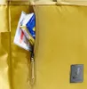 A close-up view of a yellow bag with a zipper pocket containing some items. Produktbild-Vorschau