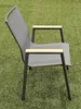 A gray outdoor chair with wooden armrests sits on a green lawn. Produktbild-Vorschau