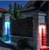 Zwei Solar-Zaunleuchten auf Steinpfosten, eine emittiert blaues Licht und die andere rotes, beleuchten nachts einen dunkelgrauen Zaun Náhľad obrázku produktu