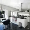 A modern, minimalist kitchen with a sleek island, dining table, and large windows. Podgląd zdjęcia produktu