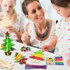 A mother and two daughters are crafting Christmas trees together at a table. Produktbild-Vorschau