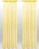Two yellow sheer curtains hanging on a rod. Podgląd zdjęcia produktu