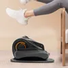 A person's legs and feet are shown exercising on a compact elliptical machine placed on the floor. Podgląd zdjęcia produktu