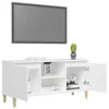 A white TV cabinet with wooden legs and a television mounted on the wall above it. Podgląd zdjęcia produktu