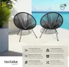 Two black chairs on a patio with a view of the ocean. Náhled obrázku produktu