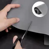 A hand is cutting a gray protective mat with scissors. Náhled obrázku produktu