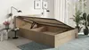 A wooden bed frame with the storage compartment open, showing the slatted base lifted by hydraulic arms. The bed is in a room with wall lamps and plants. Produktbild-Vorschau