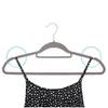 A gray velvet hanger holding a black and white floral dress. Produktbild-Vorschau