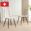 Two beige upholstered dining chairs with black metal legs are shown in a room with a light-colored wall and wooden paneling. Produktbild-Vorschau