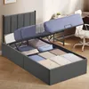 A bed frame with its mattress lifted to reveal storage compartments underneath, showcasing the product's features. Náhled obrázku produktu