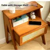 A wooden nightstand with storage shelves and a drawer, decorated with books, a phone, and a small astronaut figurine. Náhled obrázku produktu