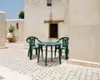 An outdoor patio area with a small table and two chairs. Anteprima dell’immagine prodotto