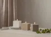 Three cube-shaped candles with a bubble texture are arranged on a white surface in front of a beige curtain. Podgląd zdjęcia produktu