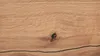 A close-up view of a wooden surface with a prominent knot and a dark line running through it. Produktbild-Vorschau