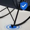 Close-up of the base of a black rocking chair on a light-colored floor, with a blue shield icon and concentric blue circles indicating stability or safety. Náhled obrázku produktu