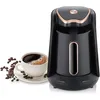 A black Turkish coffee maker with gold accents sits next to a cup of coffee and coffee beans. Produktbild-Vorschau