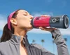 A woman drinking a smoothie from a portable blender outdoors. Podgląd zdjęcia produktu