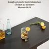 A bar table with a decanter, a bottle of water, and a cocktail, along with some lemons and rosemary, on a dark wood surface. Podgląd zdjęcia produktu