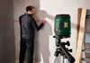 A man is using a laser level to mark lines on a wall. Produktbild-Vorschau