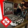 A man is working on a bicycle in a workshop, with a toolbox open in the foreground. Podgląd zdjęcia produktu