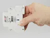 A hand is holding a white electrical component against a white background. Produktbild-Vorschau