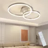 A modern living room with a sectional sofa, a piece of abstract art on the wall, and a contemporary ceiling light fixture. Podgląd zdjęcia produktu