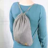 A person wearing a blue sweater and a gray drawstring backpack. Anteprima dell’immagine prodotto