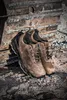 A pair of brown Puma work shoes are leaning against a piece of heavy machinery on a construction site. Anteprima dell’immagine prodotto