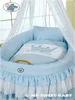 A baby bassinet with blue bedding and a white canopy. Produktbild-Vorschau
