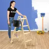 A woman is painting a wall with a ladder, paint roller, and bucket. Voir les images du produit